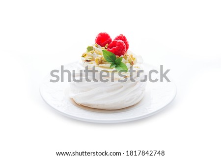 dessert Anna Pavlova with raspberries and cream on a saucer isolated on a white background