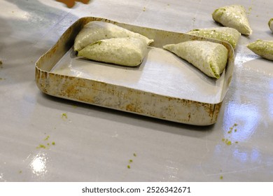 A dessert chef places the desserts and chocolate layers on a baking tray to bake them. close-up tray and desserts. Traditional Turkish desserts. Culinary arts. Pastries. Turkey. - Powered by Shutterstock