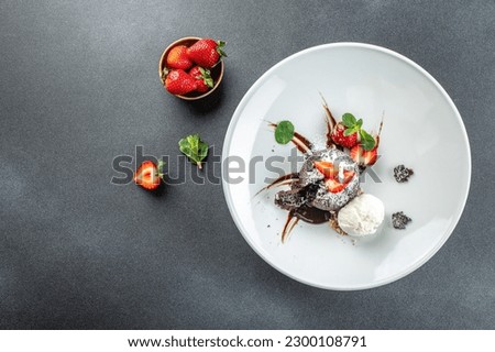 dessert chocolate cake Fondant served on plate with fresh strawberries, ice-cream ball and mint, banner, menu, recipe place for text, top view,