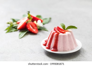 Dessert, creamy strawberry pudding with sauce on a plate on a light background - Shutterstock ID 1990081871