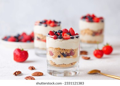 Dessert in a glasses with berries, whipped cream and biscuit. Healthy food, vegan, sugar, gluten and lactose free. Berry dessert, cheesecake, trifle, mouse in a glass.