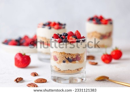 Dessert in a glasses with berries, whipped cream and biscuit. Healthy food, vegan, sugar, gluten and lactose free. Berry dessert, cheesecake, trifle, mouse in a glass.
