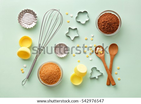 Dessert ingredients and utensils on green pastel background. Top view
