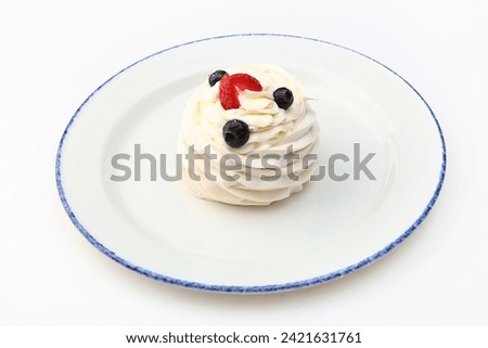 Dessert of meringue and berries on plate. Cake with fresh blueberries and strawberries. Whipped cream. White background.