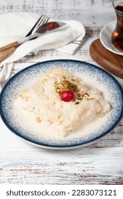 Güllaç dessert on wood background. Traditional Ramadan dessert. Güllaç dessert topped with sour cherry and pistachio - Shutterstock ID 2283073121
