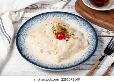 Güllaç dessert on wood background. Traditional Ramadan dessert. Güllaç dessert topped with sour cherry and pistachio - Shutterstock ID 2283073149