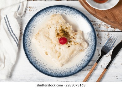 Güllaç dessert on wood background. Traditional Ramadan dessert. Güllaç dessert topped with sour cherry and pistachio. Top view - Shutterstock ID 2283073163