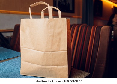 dessert paper bag waiting for customer on counter in modern cafe coffee shop, food delivery, cafe restaurant, takeaway food.