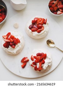 Dessert Pavlova With Cream And Strawberries  With Gold Spoon On The Marble Serving Tray.