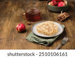 Dessert, sliced sponge roll with apple filling, on a rectangular plate on a brown wooden background. Apple recipes. Thanksgiving Day