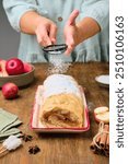 Dessert, sponge roll with apple filling, on a rectangular plate on a brown wooden background. Apple recipes. Thanksgiving Day