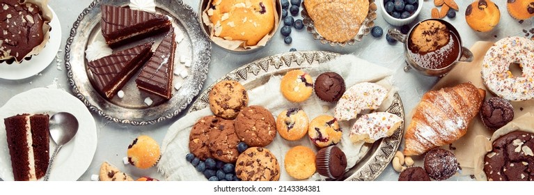 Dessert table with all kinds snacks on light background. Candy bar. Celebration concept. Top view, flat lay, panorama - Shutterstock ID 2143384381