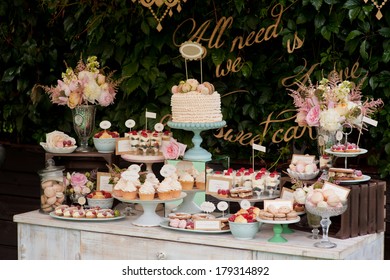 Dessert table for a party. Ombre cake, cupcakes, sweetness and flowers
