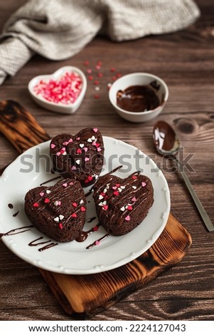 Dessert for Valentine's Day. Homemade heart shaped chocolate cupcakes on a dark wooden table. Chocolate muffins in the shape of a heart. Cooking with love concept.