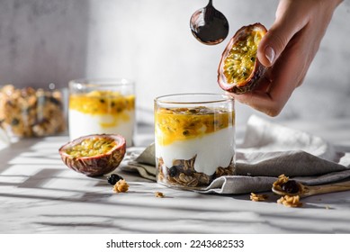 dessert with yogurt and passion fruit. dessert with yogurt and passion fruit and granola, honey in a jar and light gray background  - Powered by Shutterstock