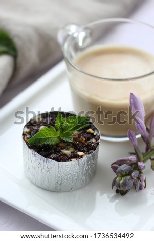 Desserts, a cup of coffee and cheesecake with chocolate on a white plate on the table. Purple flower. Background image, copy space