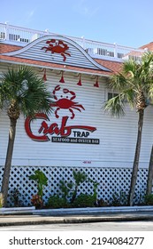 Destin, Fl, USA - April 1, 2022: Crab Trap Restaurant Seafood And Oyster Bar Front Of Restaurant With Palm Trees And Blue Sky On Sunny Morning.