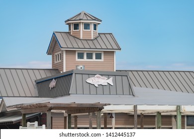 Destin, USA - April 24, 2018: Seafood Restaurant Building Or Beach House With Fish On Roof Isolated Against Blue Sky In Miramar Beach City Town Village At Gulf Of Mexico In Florida Panhandle