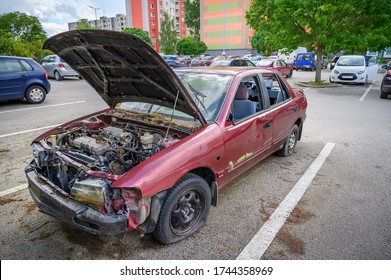 Destroyed Abandoned Car With Open Hood On Parking Lot  