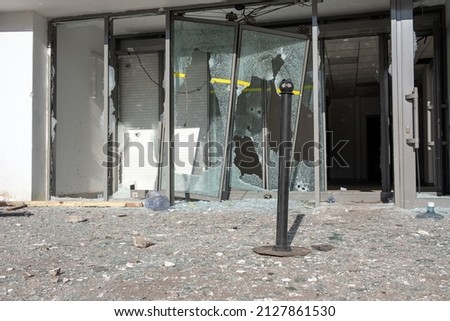 Destroyed automatic sliding glass doors in entrance of building due to vandalism. Looted shopping mall concept. Riots after protests out of control. Pillaging concept.
