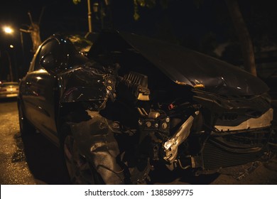 Destroyed Car After A Crash Accident. The Car Is On The Road In Night City With Low Lights.