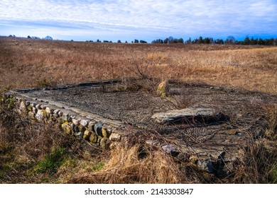 Destroyed House Foundation In The Meadow With Dried Brown Grasses On The Cloudy Day In New England, USA