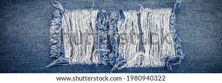 Destroyed torn denim blue jeans texture. Ripped denim blue cloth background. Recycling old jeans denim concept, banner  Foto d'archivio © 