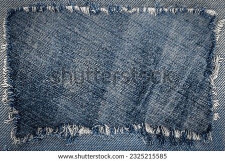 Destroyed torn denim blue jeans patch background. Denim blue jeans fabric frame. Ripped denim fabric. Recycle old jeans denim pieces concept. Many fragments of jeans cloth.