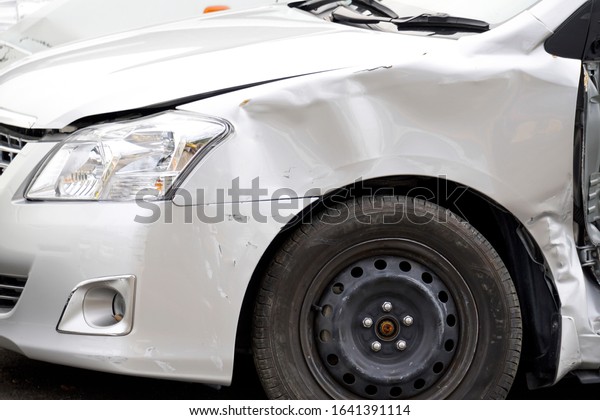 Destroyed white car door and\
tire