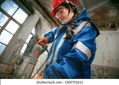 Destroying Gender Stereotypes. Woman Wearing Helmet Using Different Male Work Tools. Gender Equality. Girl Working At Flat Remodeling. Building, Repair And Renovation. Woman In The Male Profession