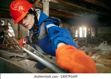 Destroying gender stereotypes. Woman wearing helmet using different male work tools. Gender equality. Girl working at flat remodeling. Building, repair and renovation. woman in the male profession