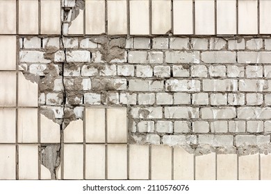 Destruction of the wall facade with falling off lined rectangular facade tiles and exposed fragments of silicate brick. Copy space.