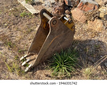 Detached Bucket Scoop Of A Small Backhoe Laying On The Ground