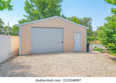 Detached gable garage exterior with steel walls and roll-up door with door latch lock