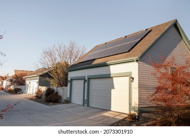 Detached gable of a three-car garage with solar panels on top of an asphalt shingle roof