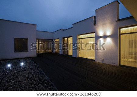 Similar – dark house at night with illuminated windows