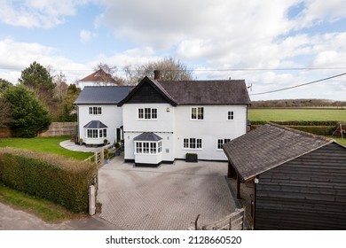 Detached White Rendered Two Storey Old Renovated House Within A Mature Setting And Wooden Shiplap Garage Taken From The Road In An Elevated Position