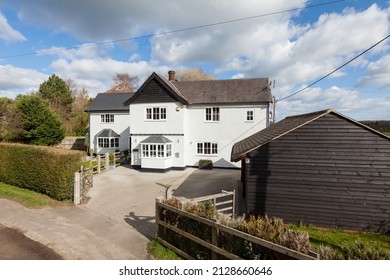 Detached White Rendered Two Storey Old Renovated House Within A Mature Setting And Wooden Shiplap Garage Taken From The Road In An Elevated Position