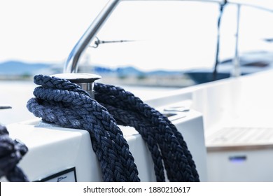 Detail Of An Anchor Rope On A Yacht. Mooring Knot On The Boat Close Up. Sealing Knot Close Up. Stainless Steel Boat Mooring Cleat With Knotted Rope Mounted On White Yacht Deck