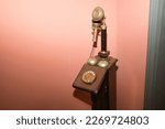 Detail of an antique candlestick telephone on a magenta background. Concept antiques, candlestick phones, calls, communications.