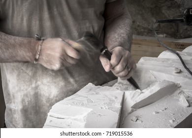 Detail Of Artist's Hands Sculpting Marble With Hammer And Chisel