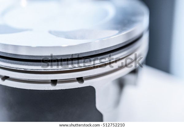 Detail of automobile\
engine piston. Photo closeup, shallow depth of field. Abstract\
industrial background.