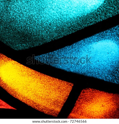 Detail of a back lit stained glass window with vibrant colors