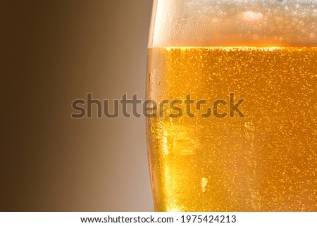 Detail of backlit beer glass with isolated background. Front view. Horizontal composition.