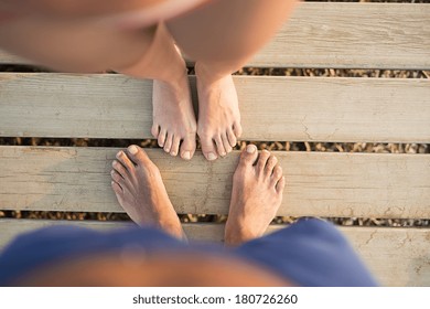 Detail Of Barefoot Couple Feet On Sunny Pier