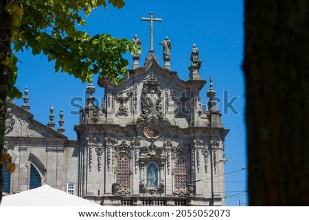 Detail of the baroque Carmo church - Igreja do Carmo main facade with a tree leaves in the foreground,