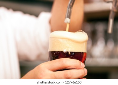 Detail Of A Bartender Drawing A Beer