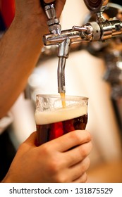 Detail Of A Bartender Drawing A Beer