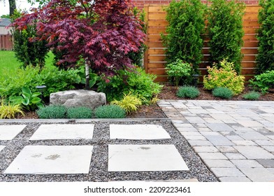Detail of a beautiful, modern Asian inspired Japanese garden with tumbled paver patio, flagstone walkway and horizontal cedar fence in an urban backyard.	 - Shutterstock ID 2209223461