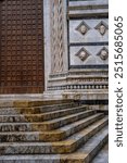 Detail of beautiful wooden doors, sculptures and stairs on the famous 13th century cathedral in Siena (Duomo di Siena). Siena, Italy 07.01.2024